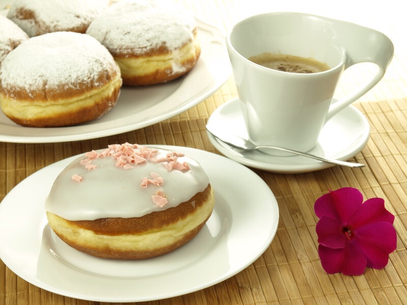 Cup of coffee with frosted donuts.