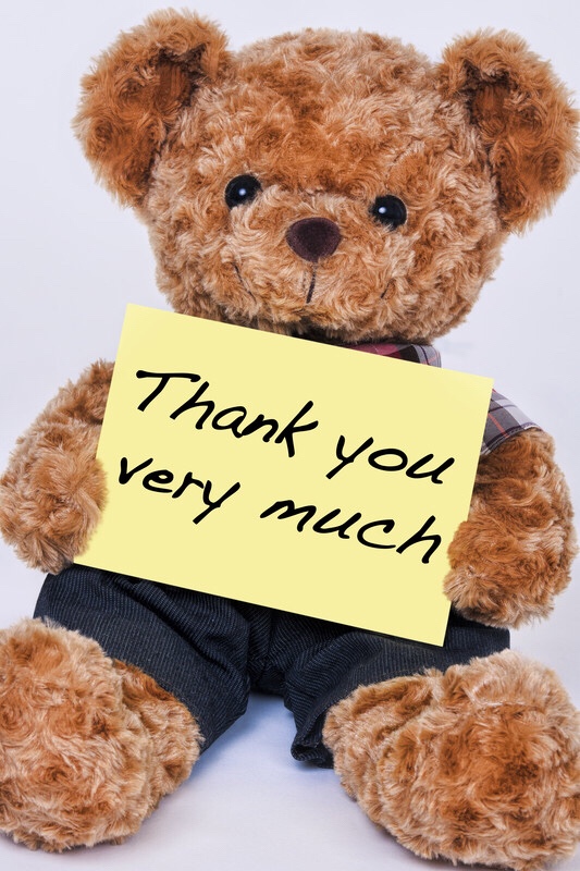 Teddy bear holding sign that reads, “thank you very much.”