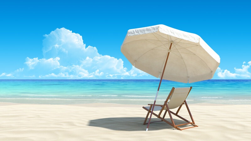 A tropical beach with a chair and umbrella.