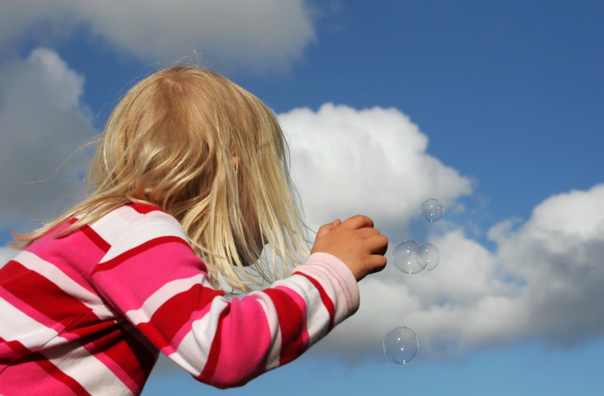 Little girl blowing bubbles.