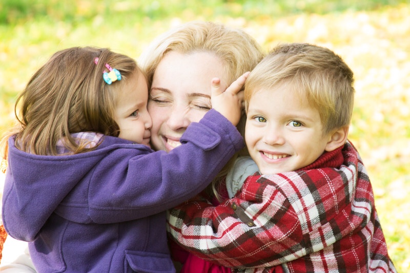 Mother hugging two children