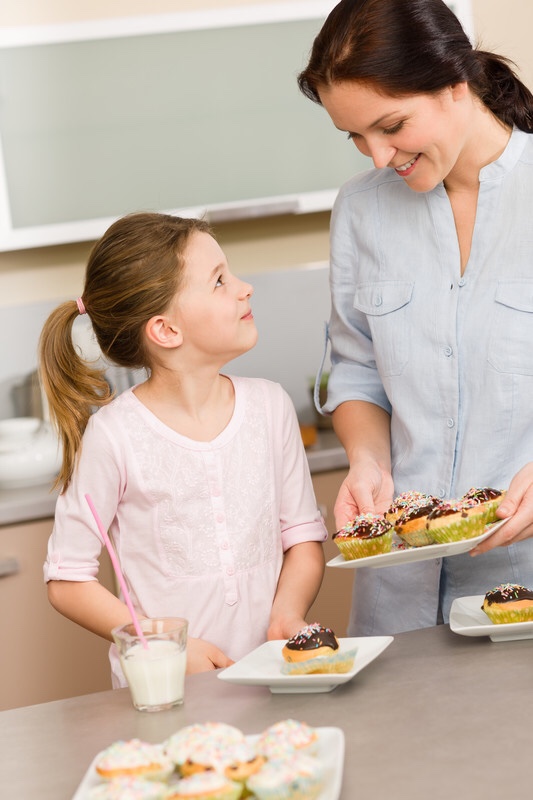 Mother and daughter tasting cupcakes