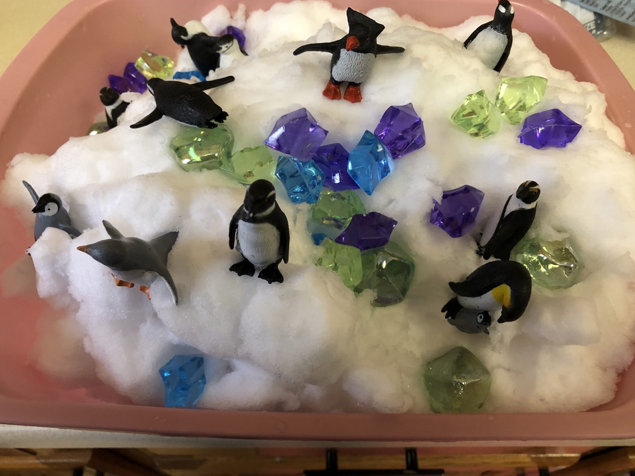 Snow sensory tub with stones and penguins