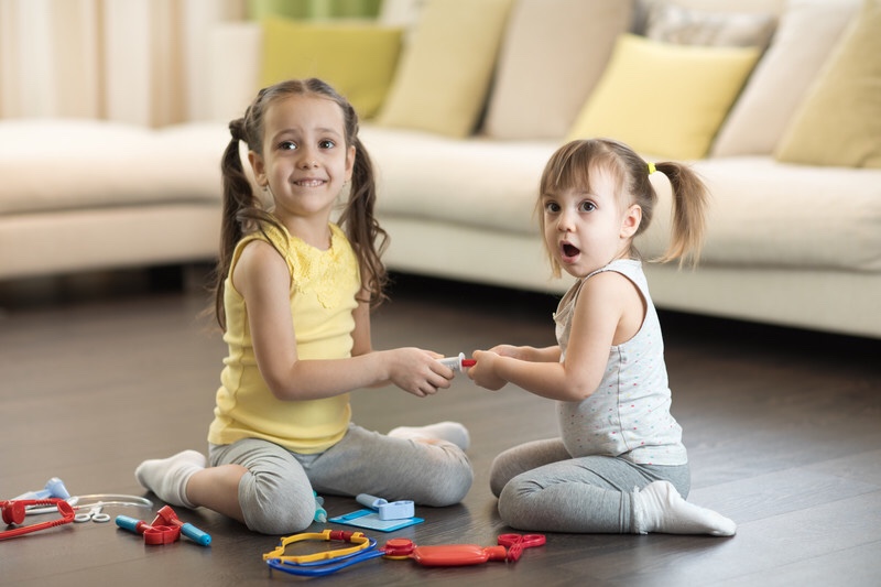 Toddler girl takes toy away.