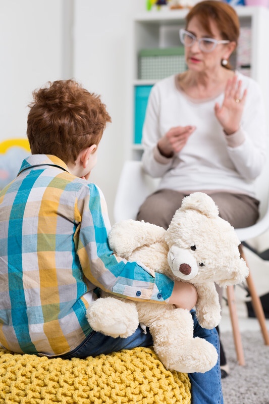 Woman teaching boy sign language