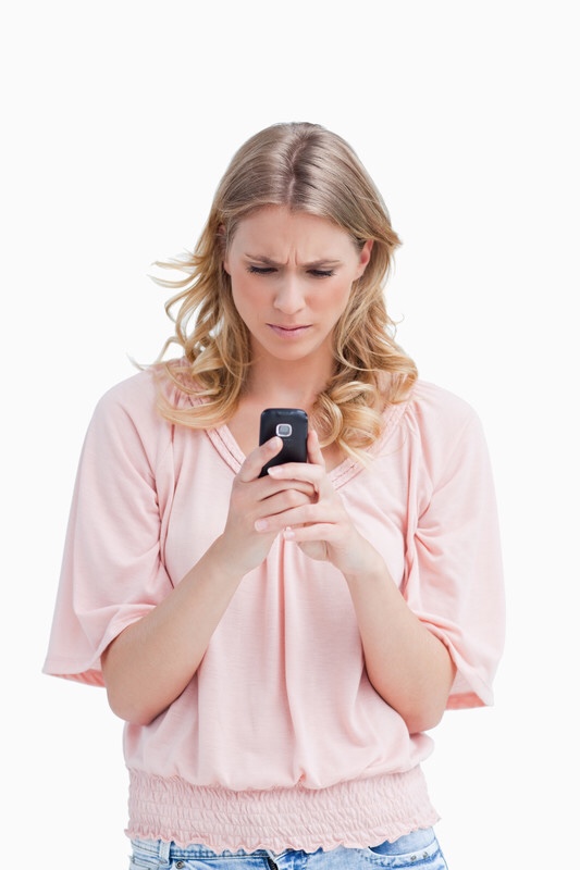 Concerned woman looking at cell phone.