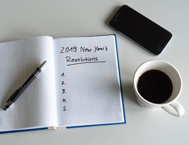 2019 New Years Resolutions written in a notebook with cup of coffee