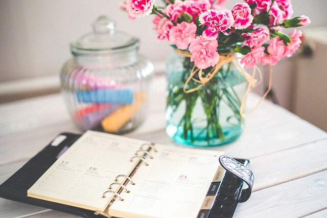 Planner on a desk with flowers