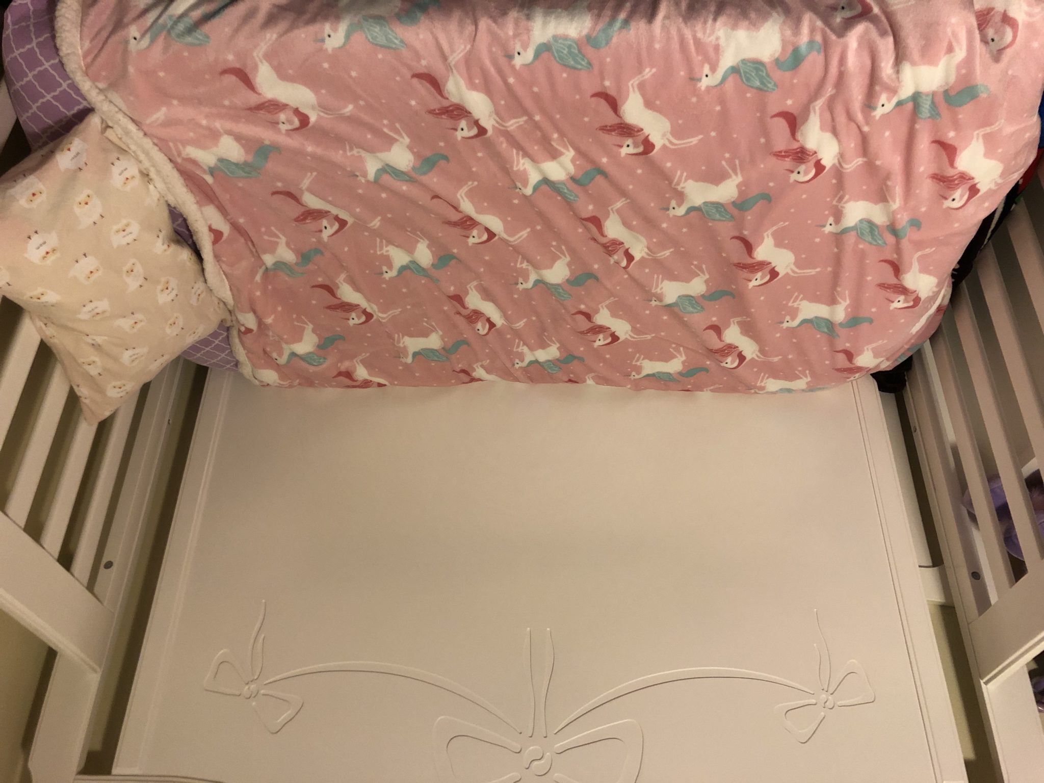 View of fully made toddler bed.