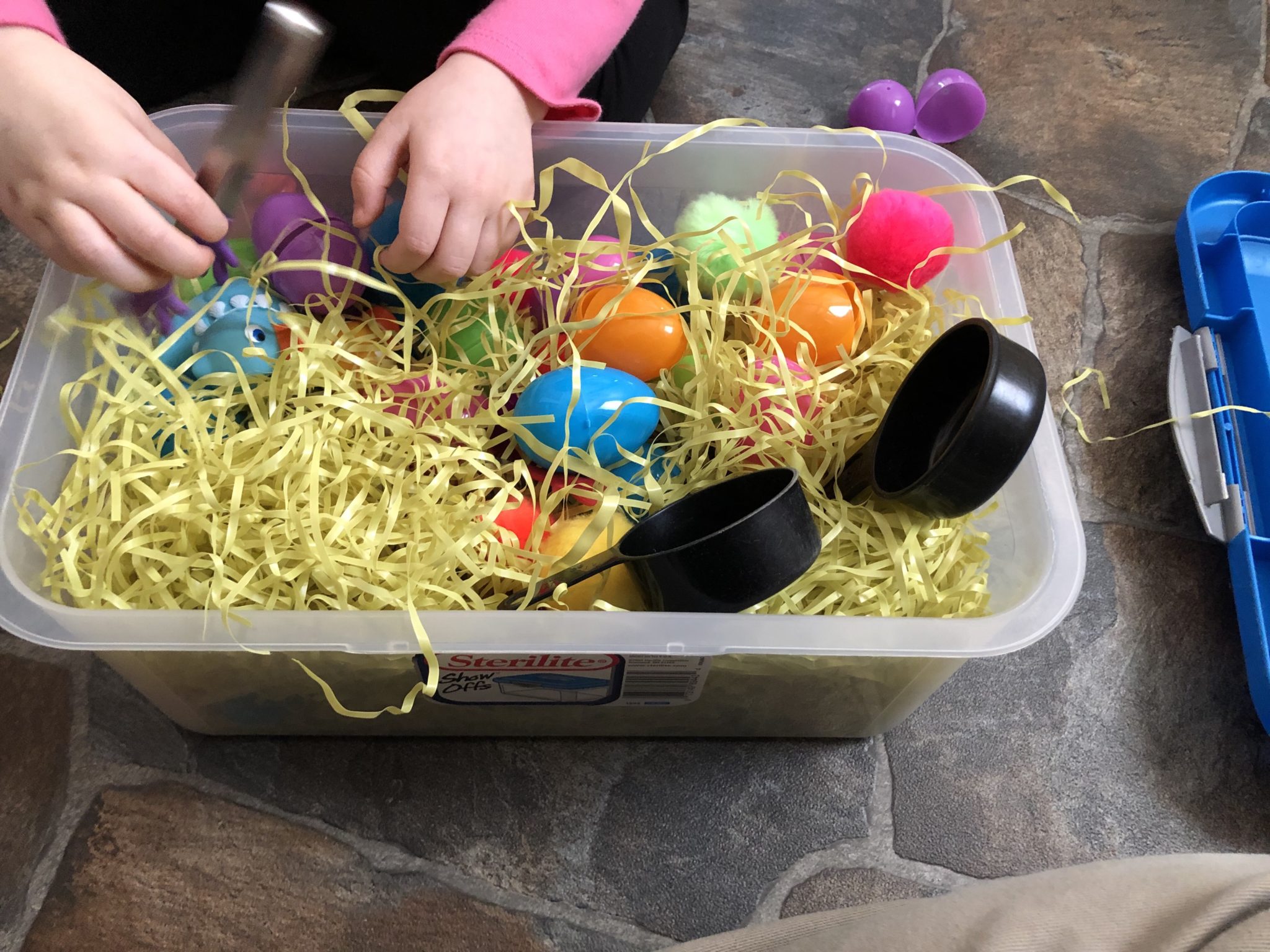 Rosebud’s hands reaching in the sensory bin