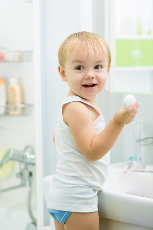 Toddler boy washing his hands.