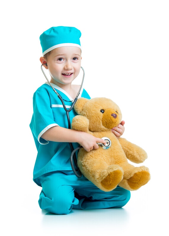 Toddler playing doctor with a teddy bear