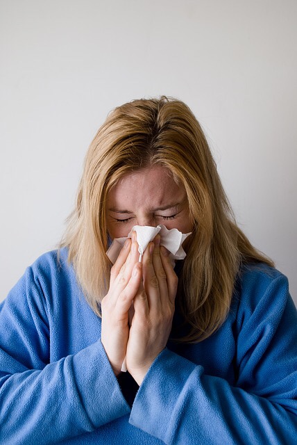 Sick woman blowing nose