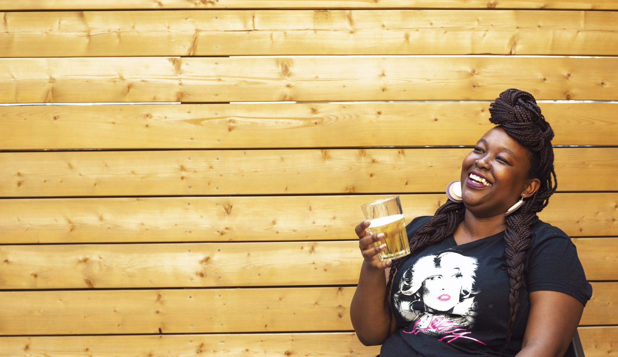 Woman laughing, enjoying drink on deck