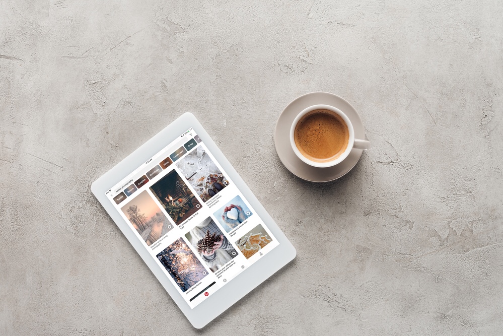 Coffee cup and a tablet with Pinterest on screen