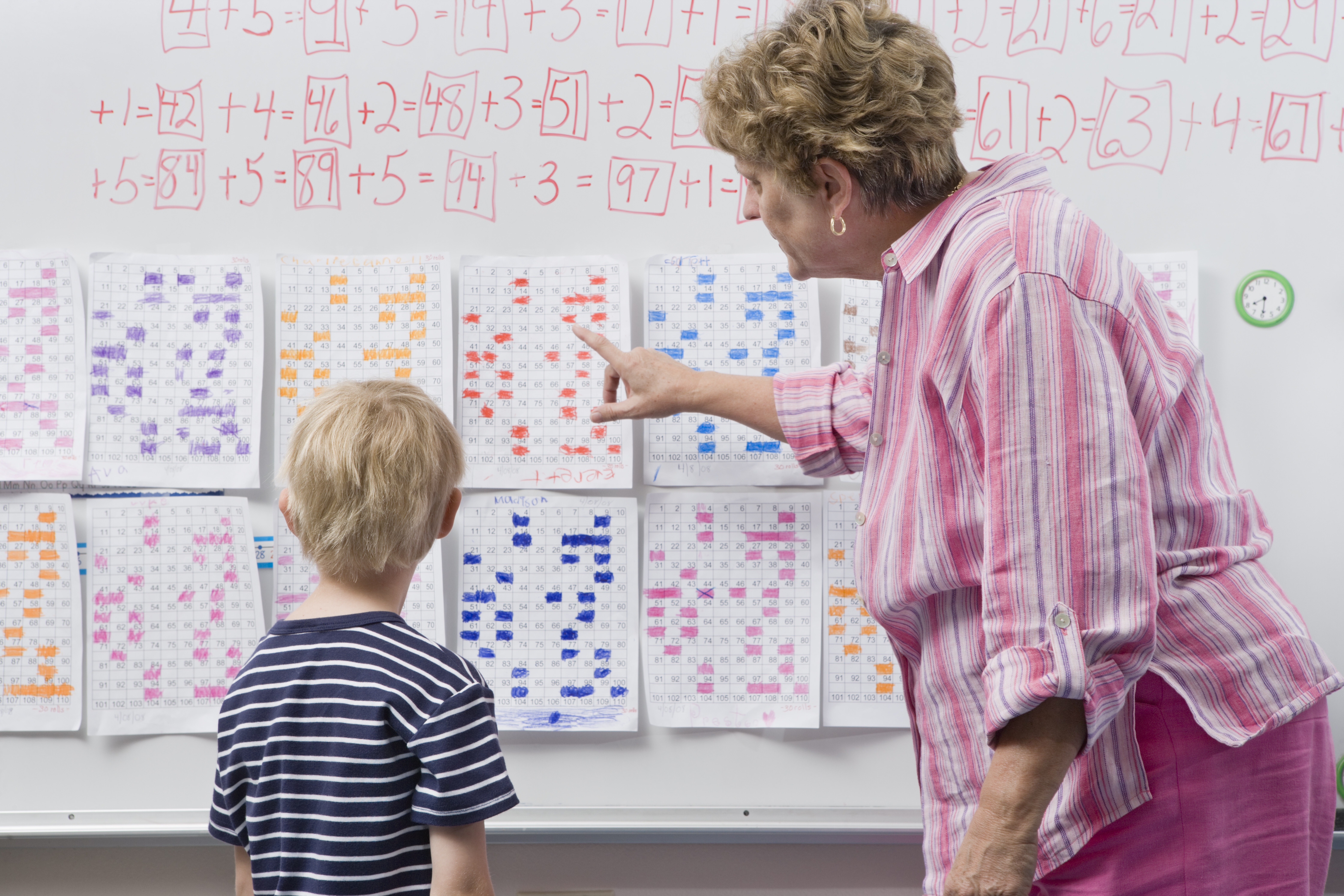 Teacher explaining calendar to little boy