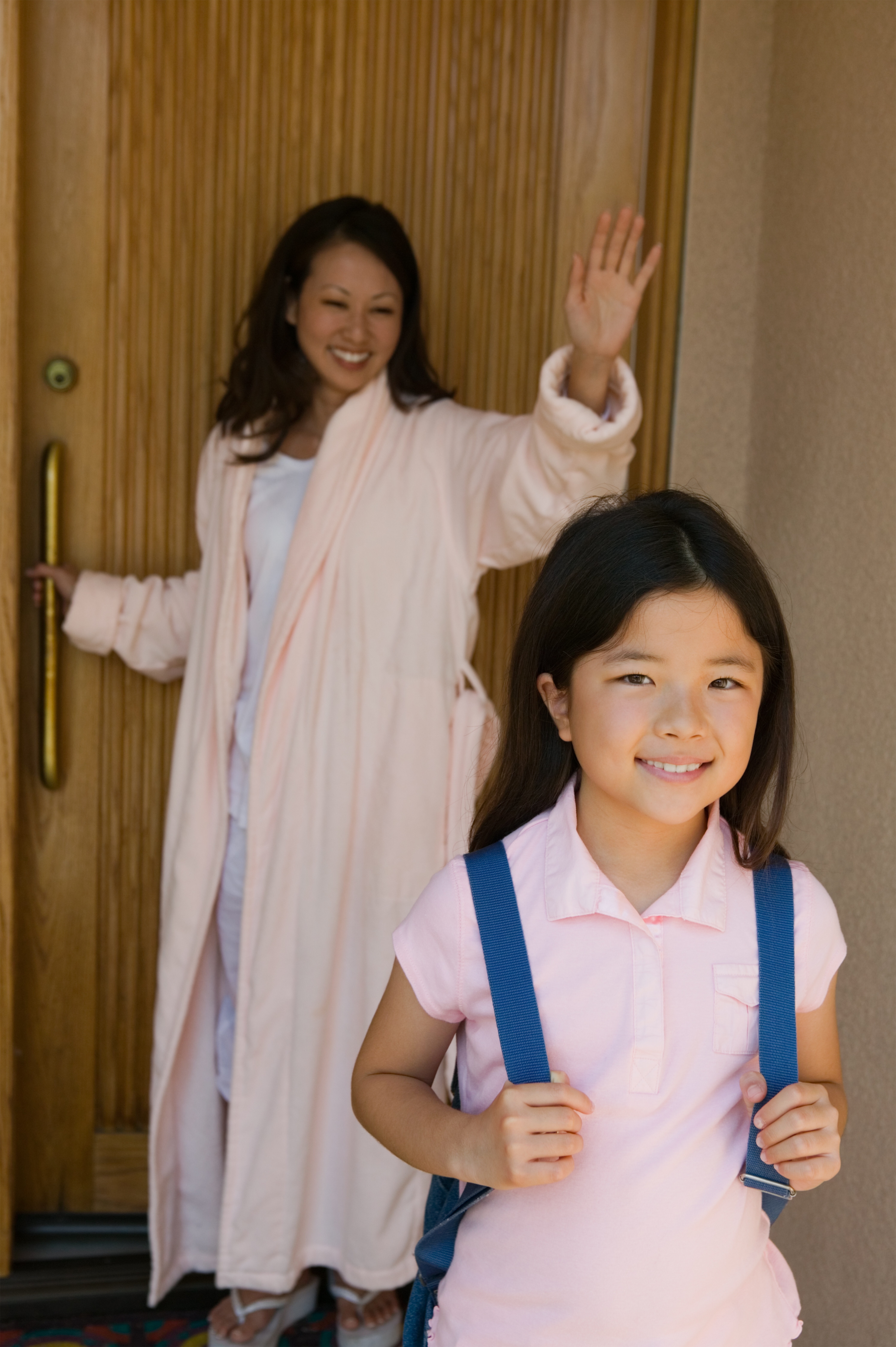 Mother waving daughter off to school