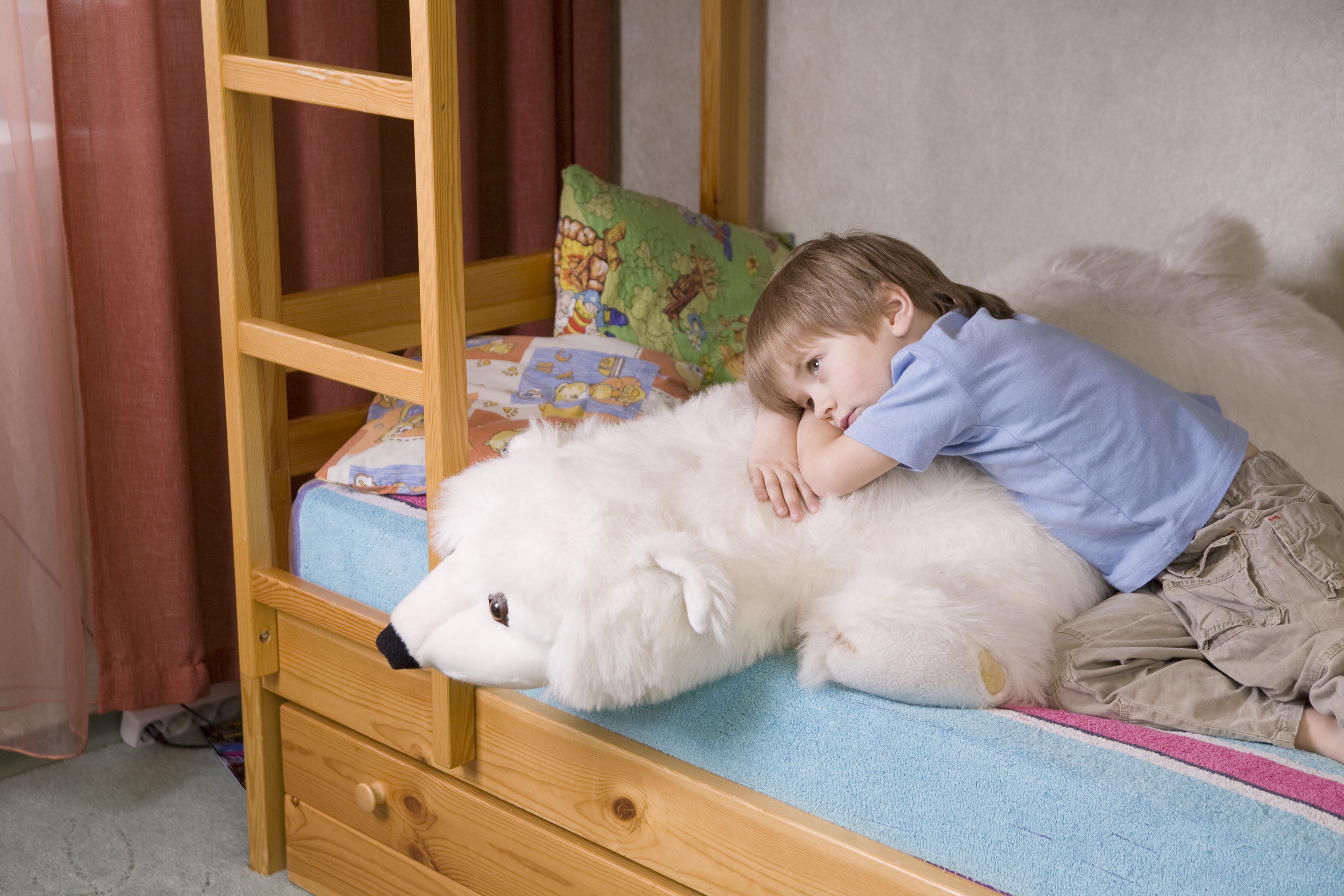 Boy at bedtime snuggling a plush polar bear