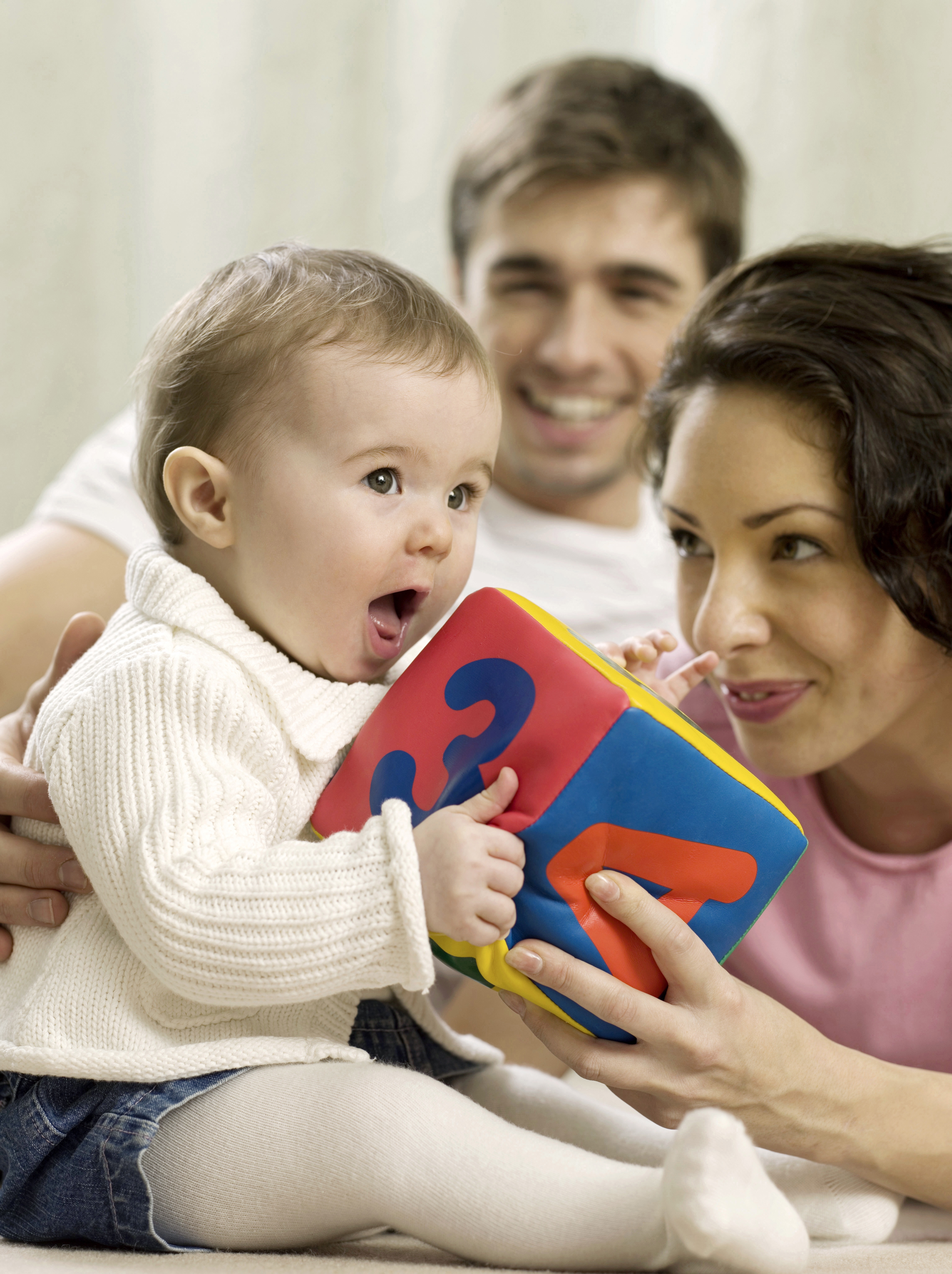 Mother and father playing with baby girl