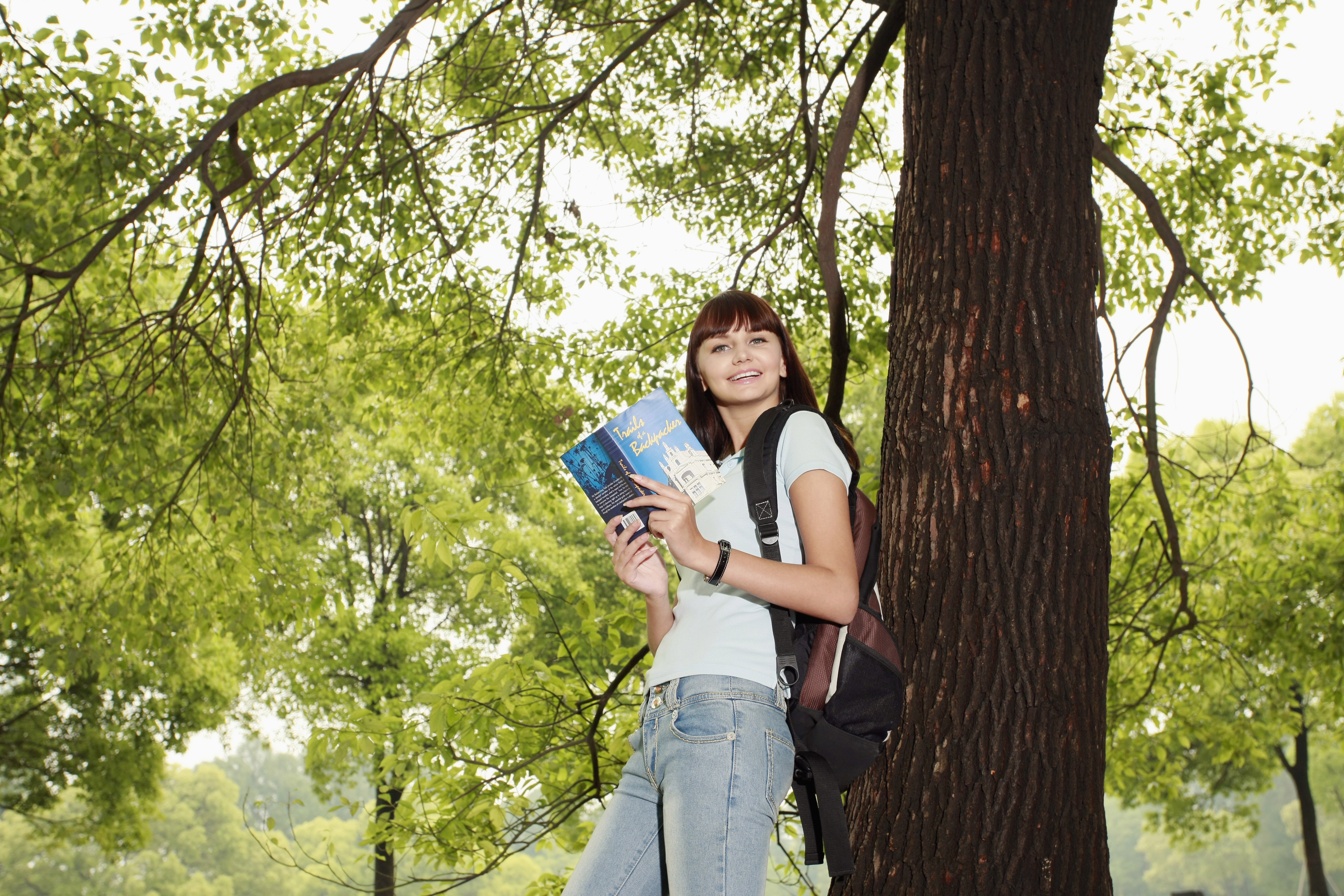 Woman reading near tree