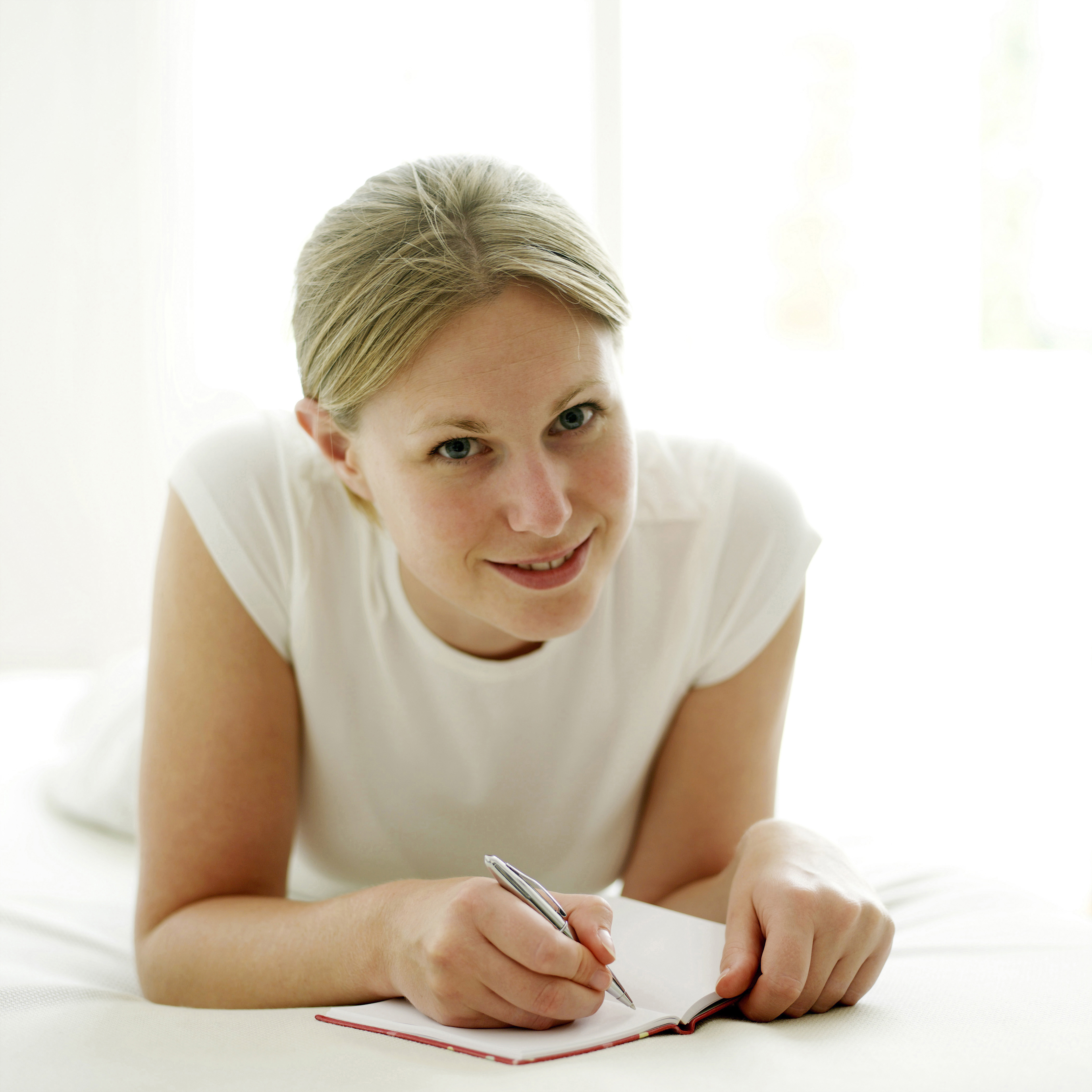 Woman journaling while laying down