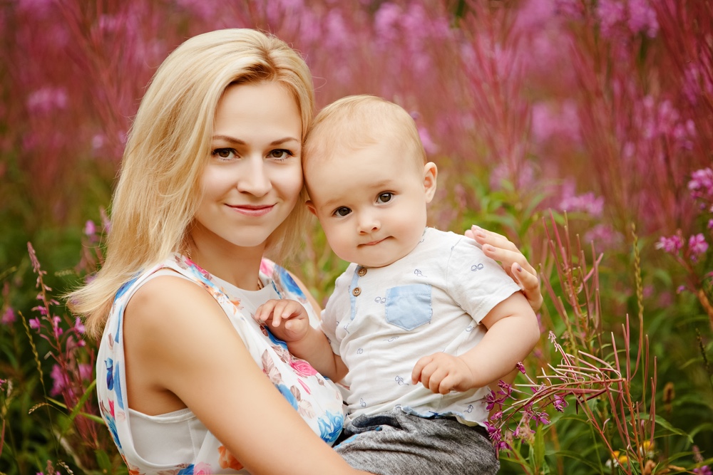 Mother and baby smiling outdoors