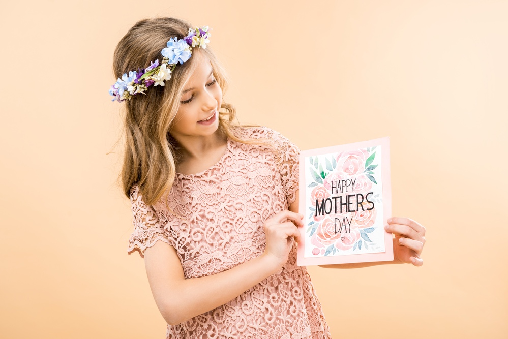 Girl in pink dress with Mother’s Day card.